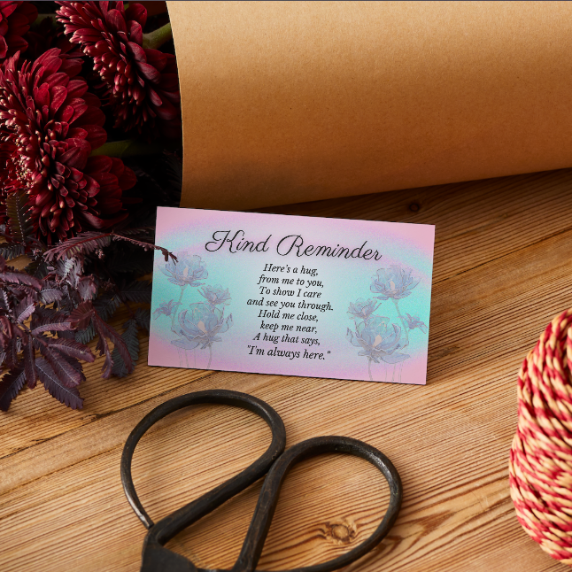Card with text on a wooden surface with flowers and scissors